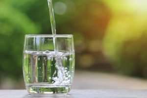 clear water getting poured into a drinking glass