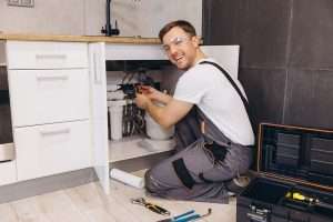 Professional plumber working on water softener