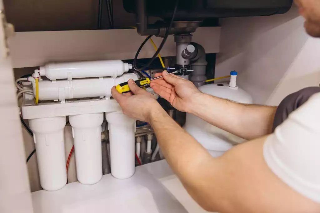 Professional plumber working on installing reverse osmosis water filter system